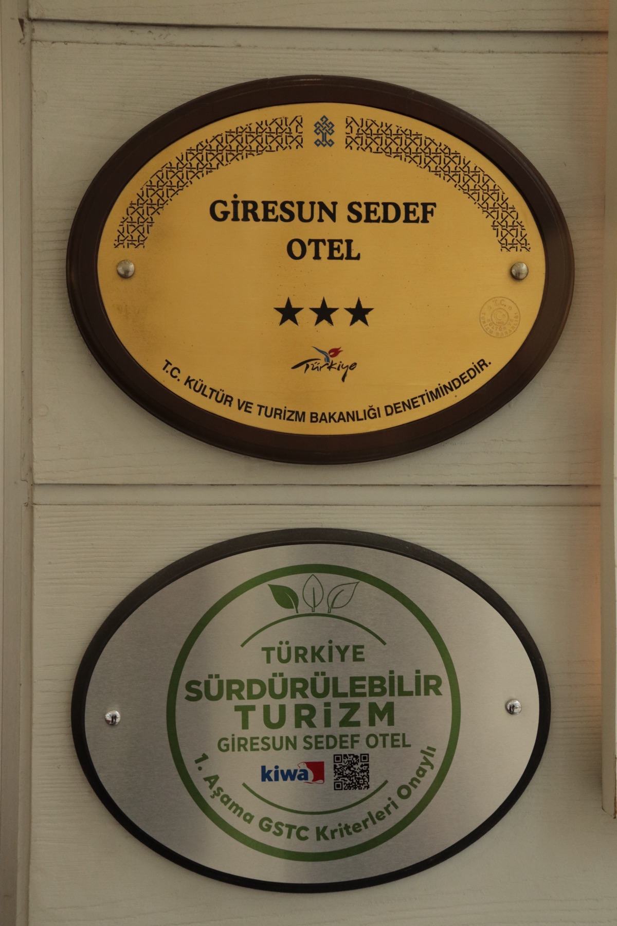 Girişte asılı üç yıldızlı Bakanlık sınıflandırma plaketi ile Türkiye Sürdürülebilir Turizm plaketi